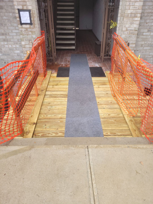 Completed pedestrian walkway bridge with galvanized railing and textured deck